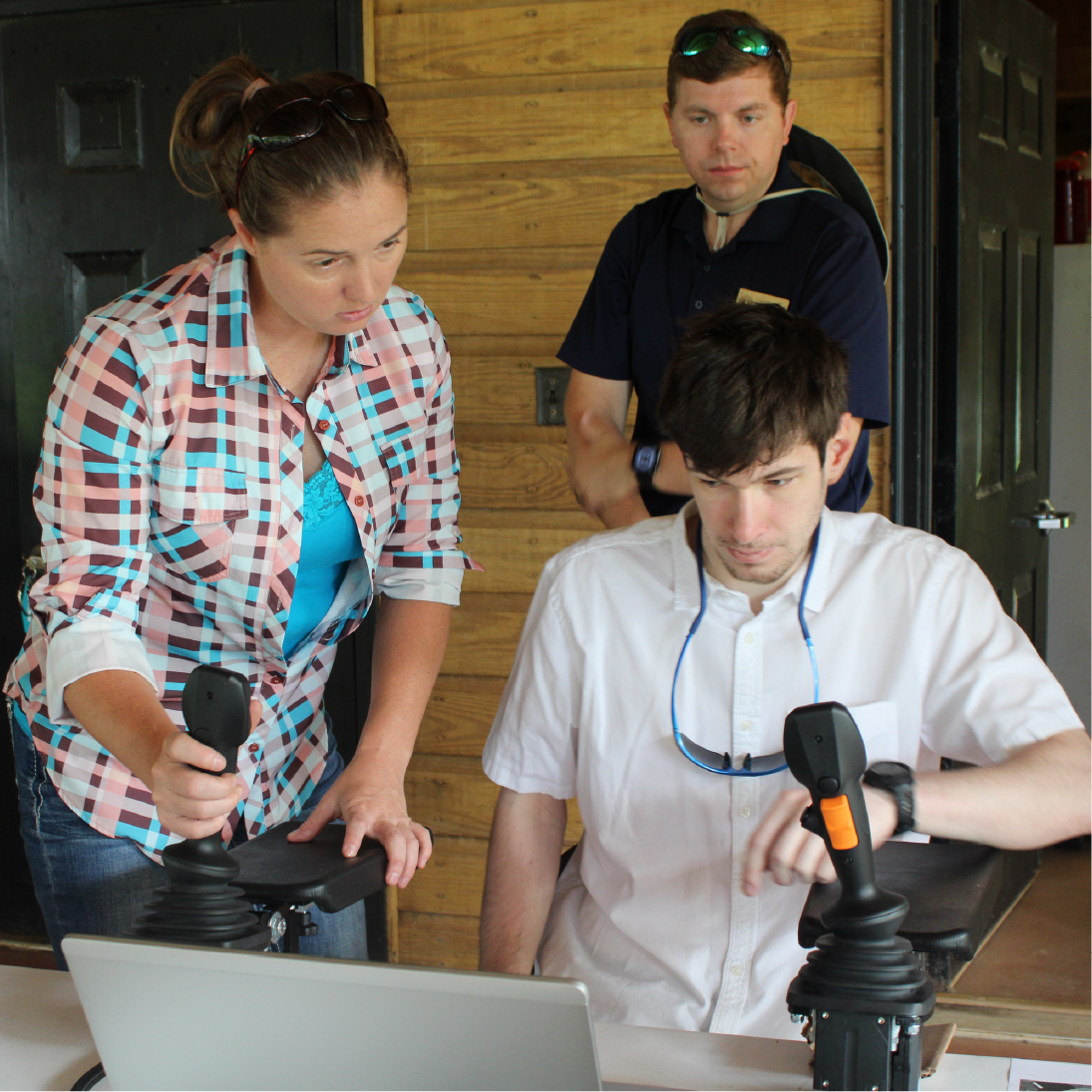 student using a John Deere forestry simulator with help from instructor