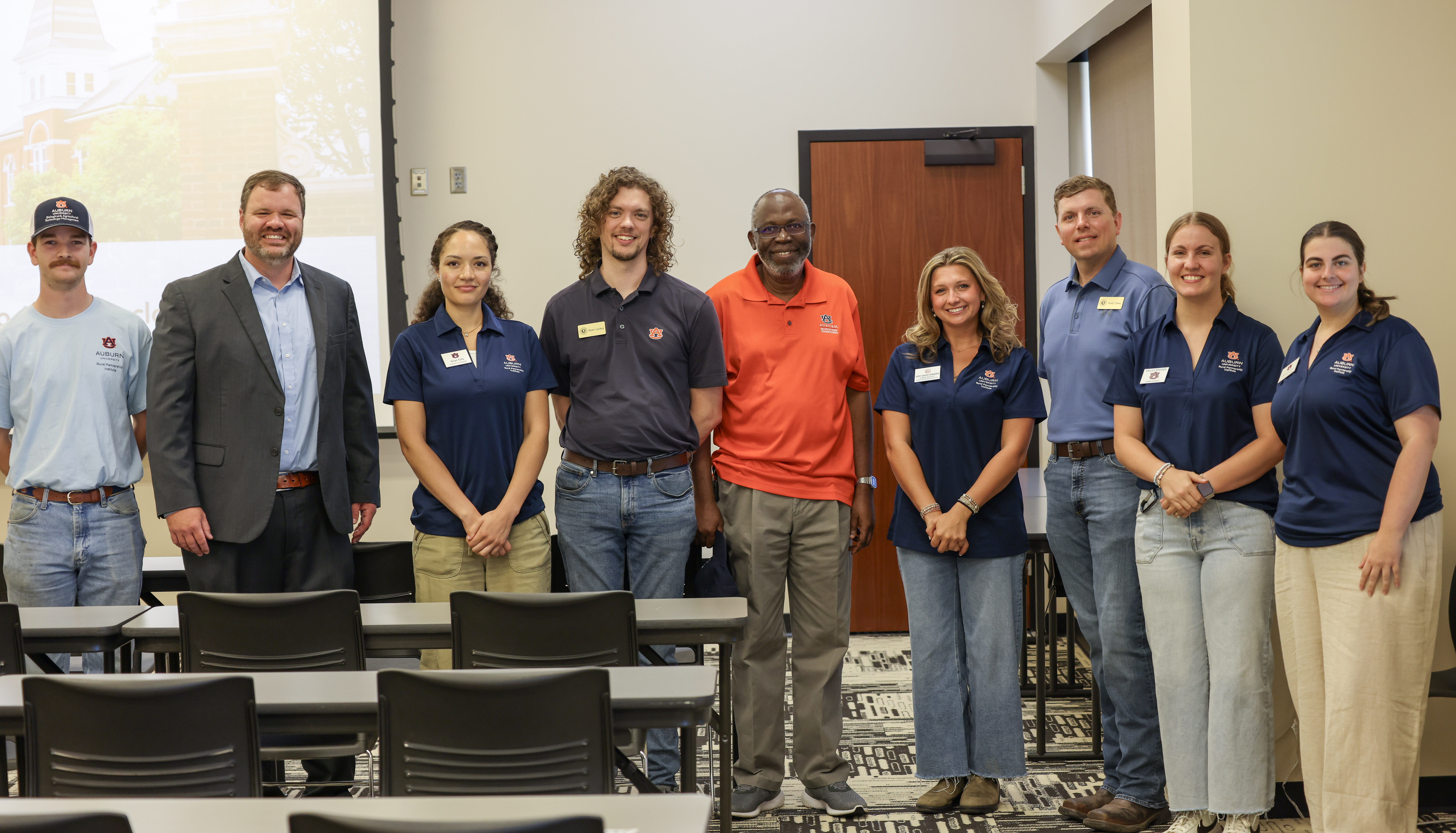 Group of AU College of Agriculture instructors standing together in a line, indoors.